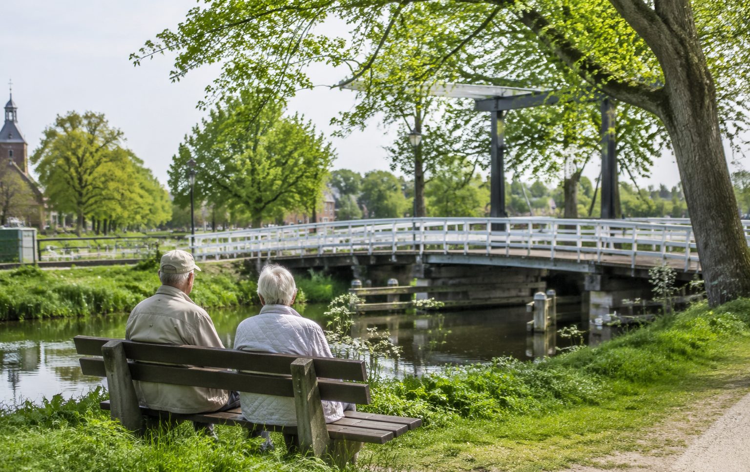 Twee deelnemers op een bankje bij een brug over een vaart bij Waalwijk